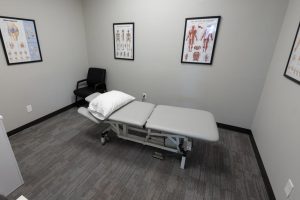 Small examination room with a hospital bed and medical posters on the walls